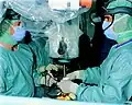 Uma equipe cirúrgica na Alemanha. Foi sugerido que cirurgiões e enfermeiros adotaram um jaleco colorido de ciano e salas de operação porque contrasta com a cor do sangue vermelho, reduzindo assim o brilho, embora a evidência para esta afirmação seja limitada.