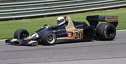 carro de corrida correndo na pista com um motorista usando capacete dentro