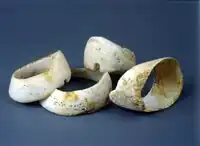 Braceletes maciços feitos a partir da concha Spondylus. Necrópole de Durankulak, túmulo 644♂, Calcolítico antigo — cultura de Hamangia III (Museu Histórico Regional de Dobrich).