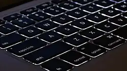 Close do teclado de um computador Macbook modelo Air com retroiluminação de teclas