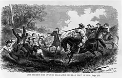 Men lined up along a tree line are shot by men on horseback.