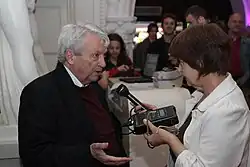 Photograph of Predrag Matvejević talking to a woman holding a tape recorder