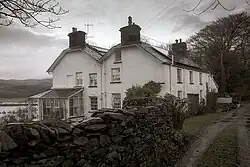 Fotografia a preto e branco de duas casas contíguas de paredes brancas.