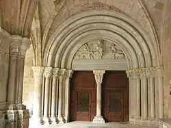 Cobertura com arquivoltas, tímpano com bênção de Cristo e tetramorfo, lintel e maineis. Claustro