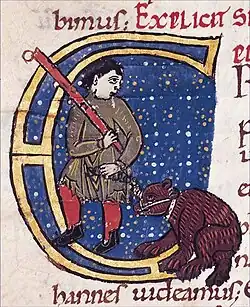 Homem a conduzir um burro com uma mordaça. Para menosprezar o burro, símbolo do paganismo antigo, a Igreja, normalmente hostil aos jograis, tolerava estes espectáculos que transformavam o animal num animal ridículo e dócil. Comentários de Santo Agostinho sobre o 'Evangelho de São João, início do século XII