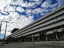 Foto da Central Acadêmica Paulo Freire em plano lateral, mostrando o prédio branco de três andares.