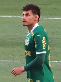 Um homem olhando pra cima. Ele está vestindo um uniforme de jogo.