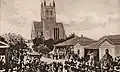 Um desfile de igreja da Marinha Real e do Exército Britânico em frente à catedral incompleta, por volta de 1900
