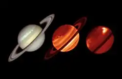 Três imagens de Saturno na mesma posição. A esquerda, o planeta aparece com coloração clara, bege, com algumas faixas em tonalidades suaves, com os anéis em formato elíptico e inclinados. No centro, o planeta aparece com faixas vermelhas, laranjas e amarelas e os aneis, na mesma posição, vemelho escuro. À direita, o planeta aparece vermelho escuro com uma mancha clara na parte superior direita, os anéis não estão visíveis.