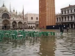 Inundações de maré. A elevação do nível do mar aumenta as inundações em regiões costeiras de baixa altitude. Na imagem: Veneza, Itália (2004).
