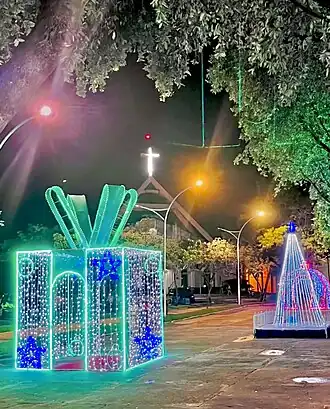 Foto da Praça Célio Miranda com decoração natalina, a principal praça de Paragominas, um cartão postal da cidade que a frente está a Igreja Matriz em honra ao Sagrado Coração de Jesus.