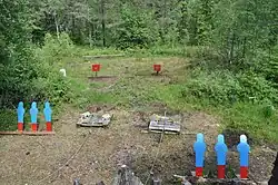 Nessa competição, o atirador usa armas de fogo diferentes durante um estágio. Nesta etapa, os revólveres foram usados nos alvos azuis mais próximos e um rifle de ação de alavanca nos alvos vermelhos mais distantes.