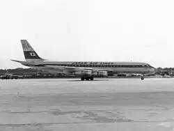 Uma fotografia em preto e branco de uma aeronave Douglas DC-8 na pista