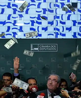 Imagem mostra Eduardo Cunha, à época presidente da Câmara dos Deputados, recebendo banho de dólares falsos contendo o seu rosto em forma de protesto contra a corrupção.