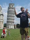 Perspectiva forçada: o homem parece estar apoiando a Torre Inclinada de Pisa ao fundo.