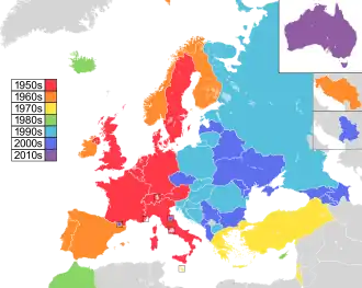 Mapa de países da Europa, Norte da África e Ásia Ocidental, com a Austrália como inserção no canto superior direito, colorido para indicar a década em que eles participaram pela primeira vez do concurso: 1950 em vermelho, 1960 em laranja, 1970 em amarelo, 1980s em verde; Década de 1990 em azul celeste; 2000s em azul; e 2010 em roxo