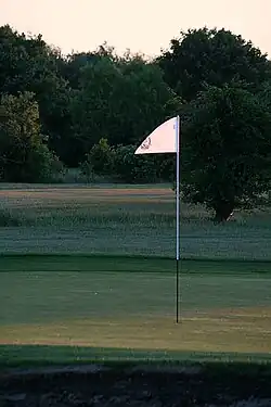 Bandeira assinalando um buraco, num campo de golfe em Inglaterra