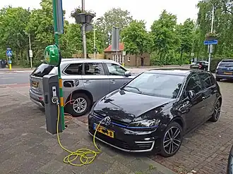 Automóveis elétricos carregando suas baterias num eletroposto.