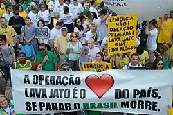 Multidão concentrada, a maioria de verde e amarelo.  Cartazes legíveis: "Congresso brasileiro vergonha nacional" e "Leniência não!  Delação premiada e Lava jato sim! Fora PL 3636".  Cartaz em primeiro plano: "A Operação Lava Jato é o ❤ [coração] do Brasil.  Se parar o Brasil morre."