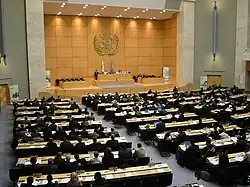 Many people gathered in a large meeting room