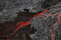 imagem de um ''rio'' de lava, e em seus arredores, a lava resfriando e criando novas formações rochosas
