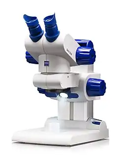 Estéreomicroscópio das cores branco e azul escuro.